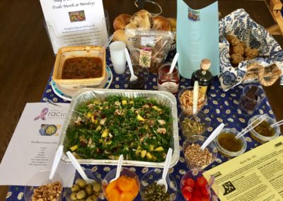 Mediterranean Foods Month food samples on table with blue tablecloth at Mondays At Racine