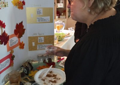 Woman reading poster board about Fall Spices at Mondays At Racine event Wendy Kaplan RD