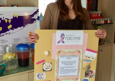 Wendy Kaplan, RD holding a poster of nutrition facts and photos at Mondays At Racine event